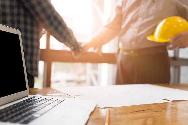 Two men standing behind a table shaking hands as they finish a labour law consultatation
