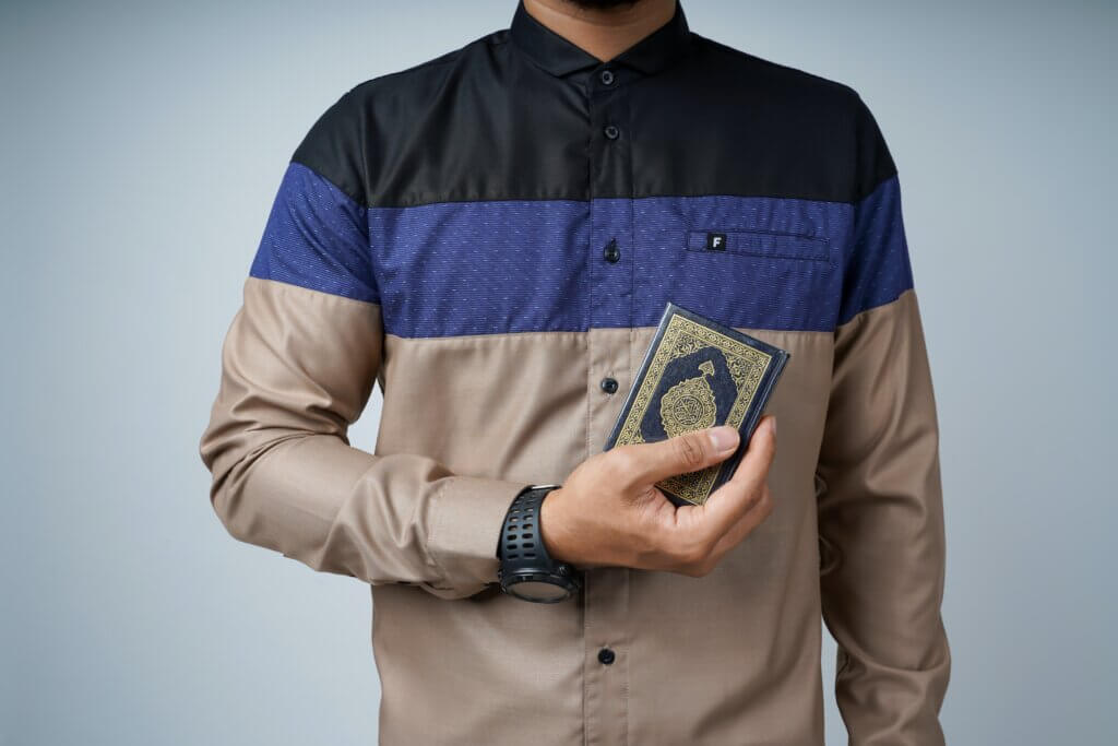Man holding Muslin prayer book.